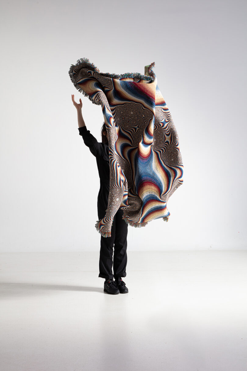 multi-colored patterned textile being held up by a person