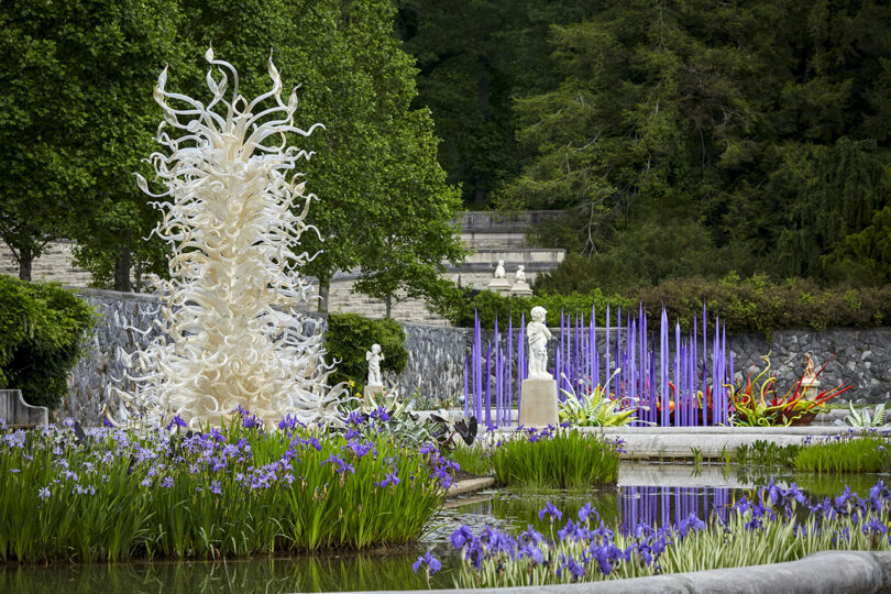 white tower of glass and vertical purple glass in a sculpted garden