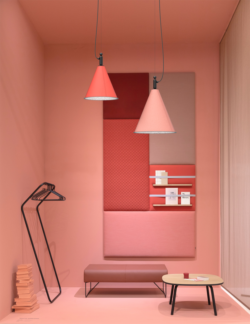 two pink cone-shaped lamps suspended about a styled living space