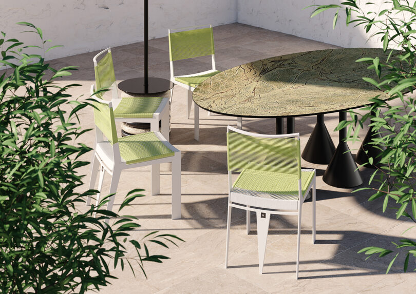outdoor round dining table and four green armchairs