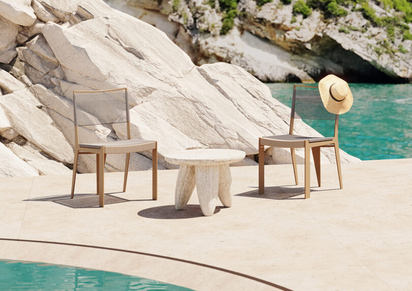 two dining chairs and a small side table by a pool