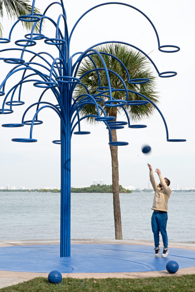 modern outdoor installation that resembles a vibrant blue palm tree with open hoops at the end of each "branch"