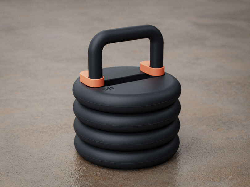 Lift stackable weight kettlebell in black set on a concrete floor.