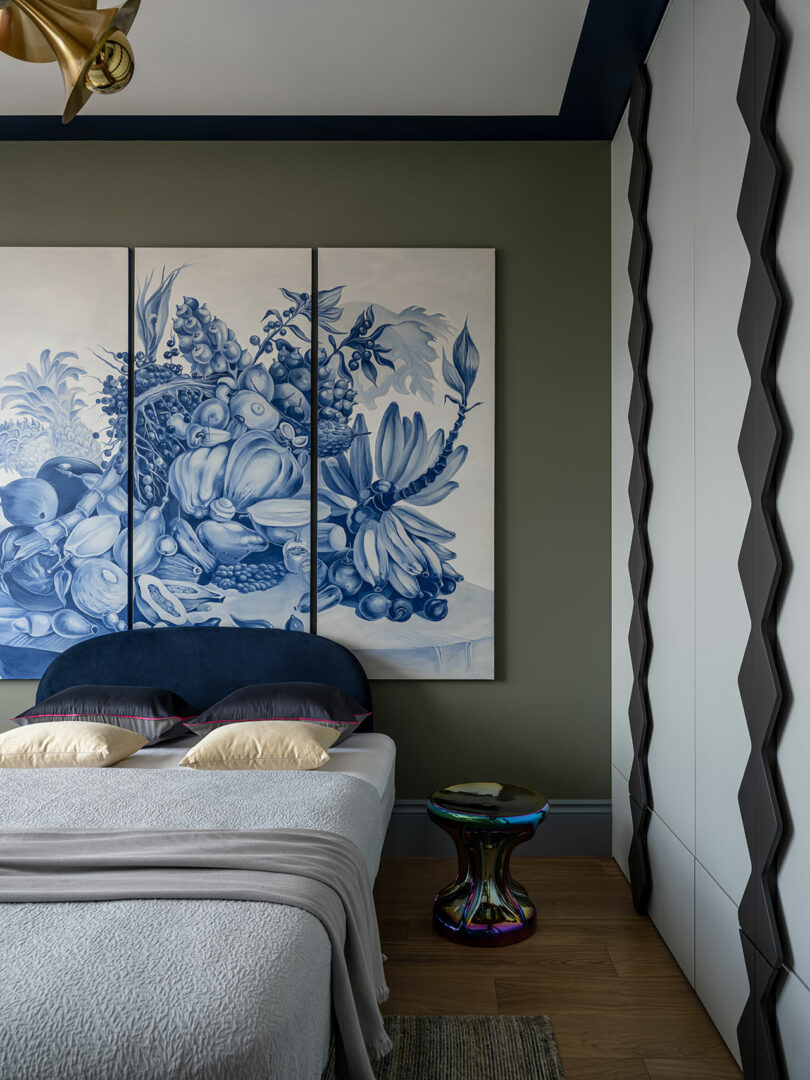 partial view of modern bedroom with large blue and white artwork above bed with light colored linens