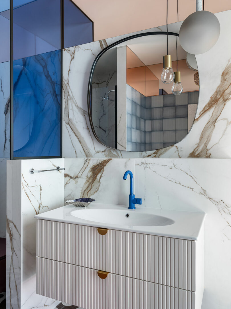 angled view of modern bathroom with swirly walls and single white sink and blue faucet