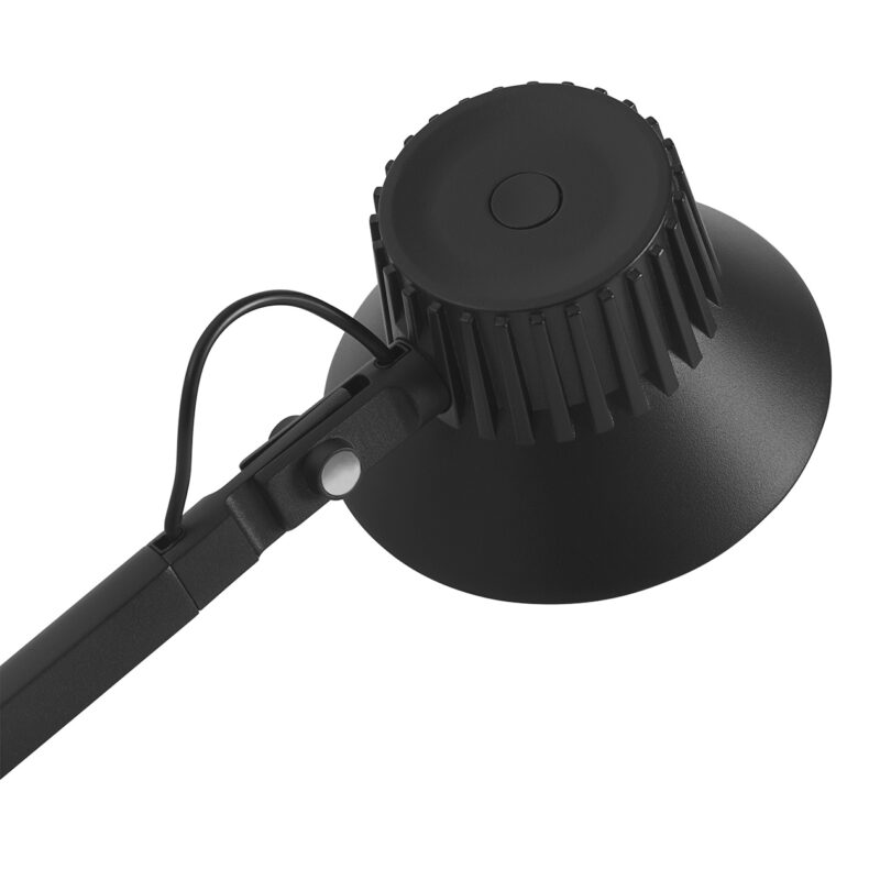 Close do botão de pressão posicionado sobre a cabeça da lâmpada de alumínio fundido sob pressão de uma lâmpada preta.