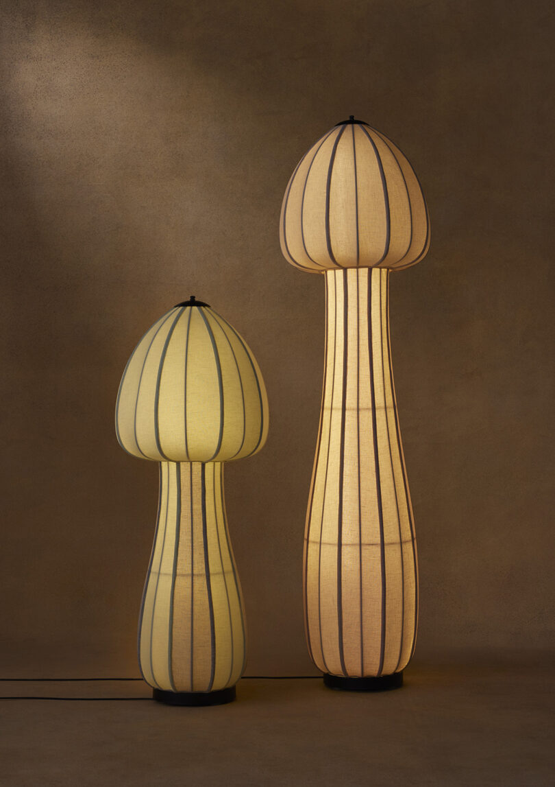 two illuminated tall mushroom-shaped floor lamps