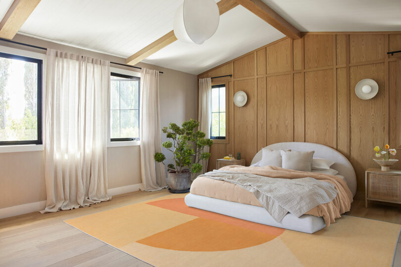angled shot of modern bedroom with modern rug in shades of peach from Ruggable Pantone collaboration
