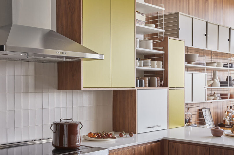 bright and airy kitchen with yellow and white cabinets along with open shelving