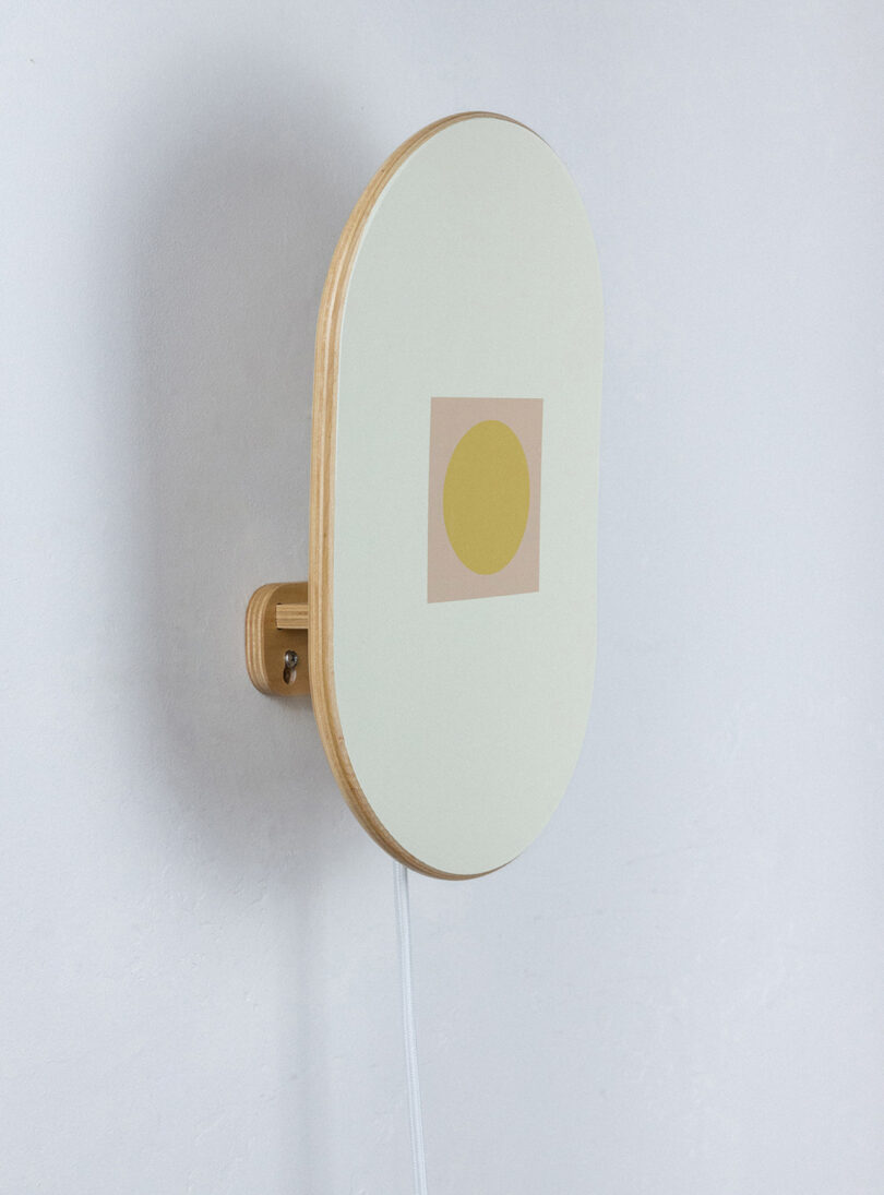 Sculptural Upton Cuna lighting made from upcycled 7-ply maple wood, wall mounted and shown from the side.