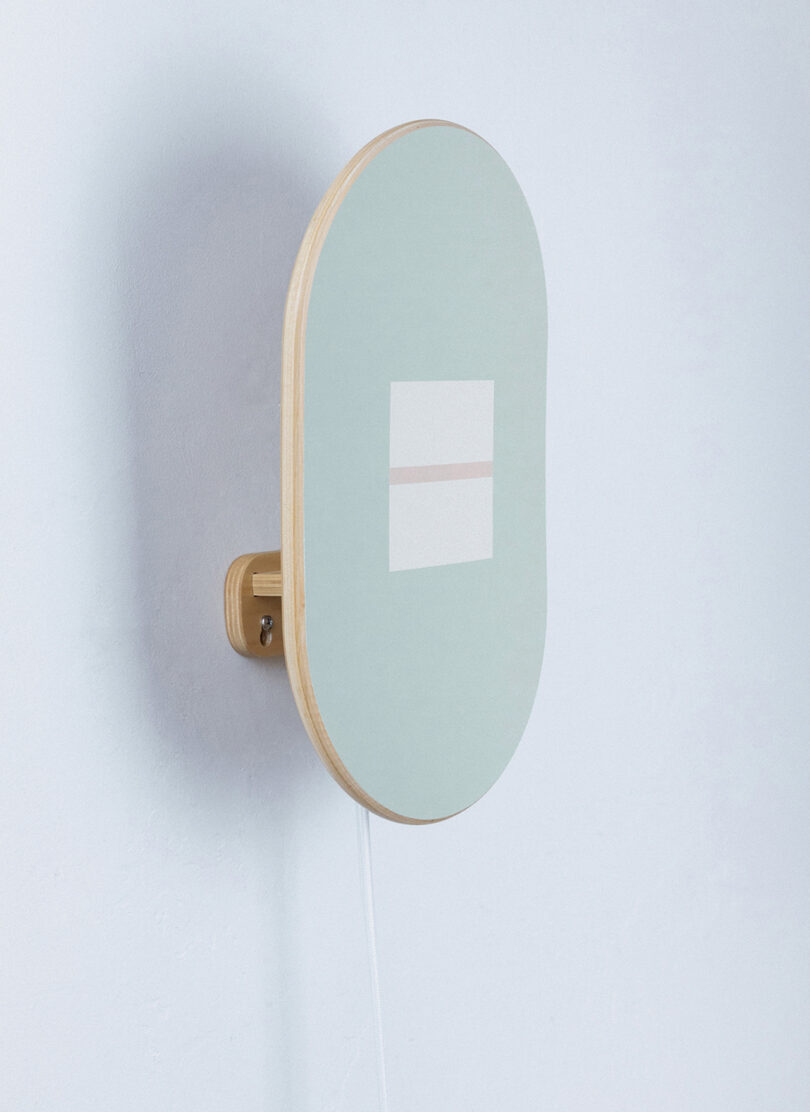 Upton MARA lighting made from upcycled 7-ply maple wood with seafoam and white graphic design.
