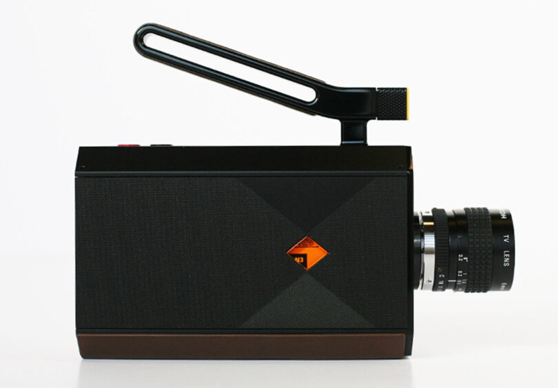 Side view of new Kodak Super 8 Camera with pistol grip and 4-inch LCD screen closed, but carrying handle up top angled upward, with lens attached.