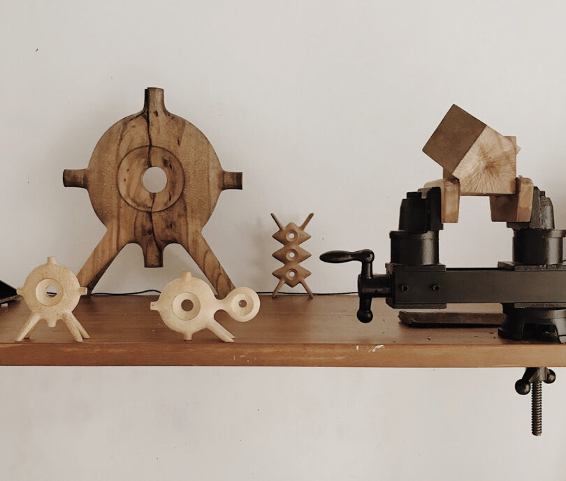 A shelf displaying the wood carved geometric sculptures of artist Aleph Geddis.