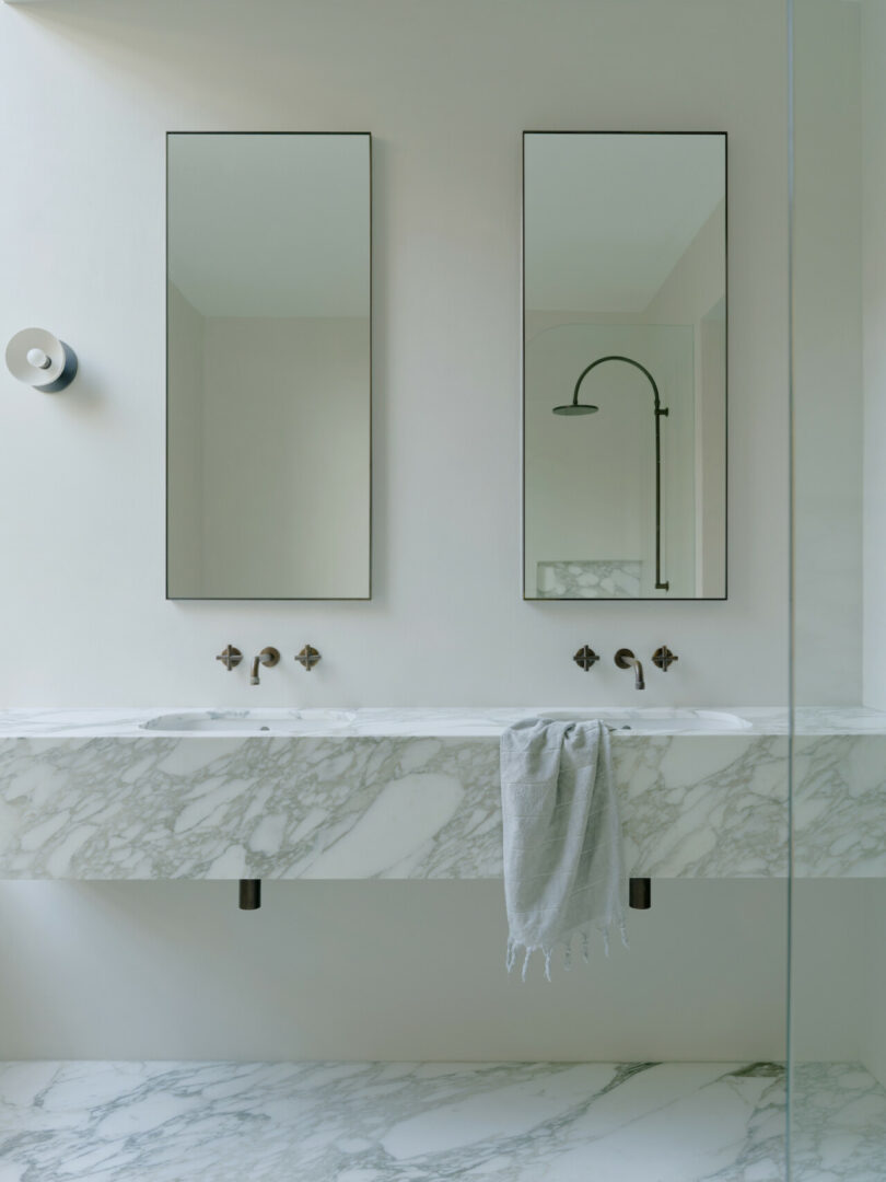 A modern bathroom vanity featuring a marble countertop