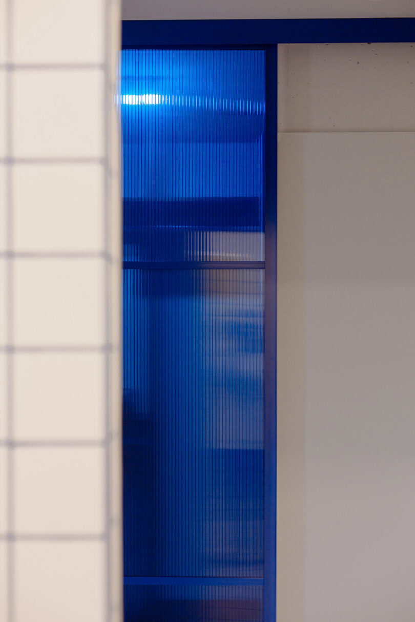 interior shot of white hallway with bright blue glass window