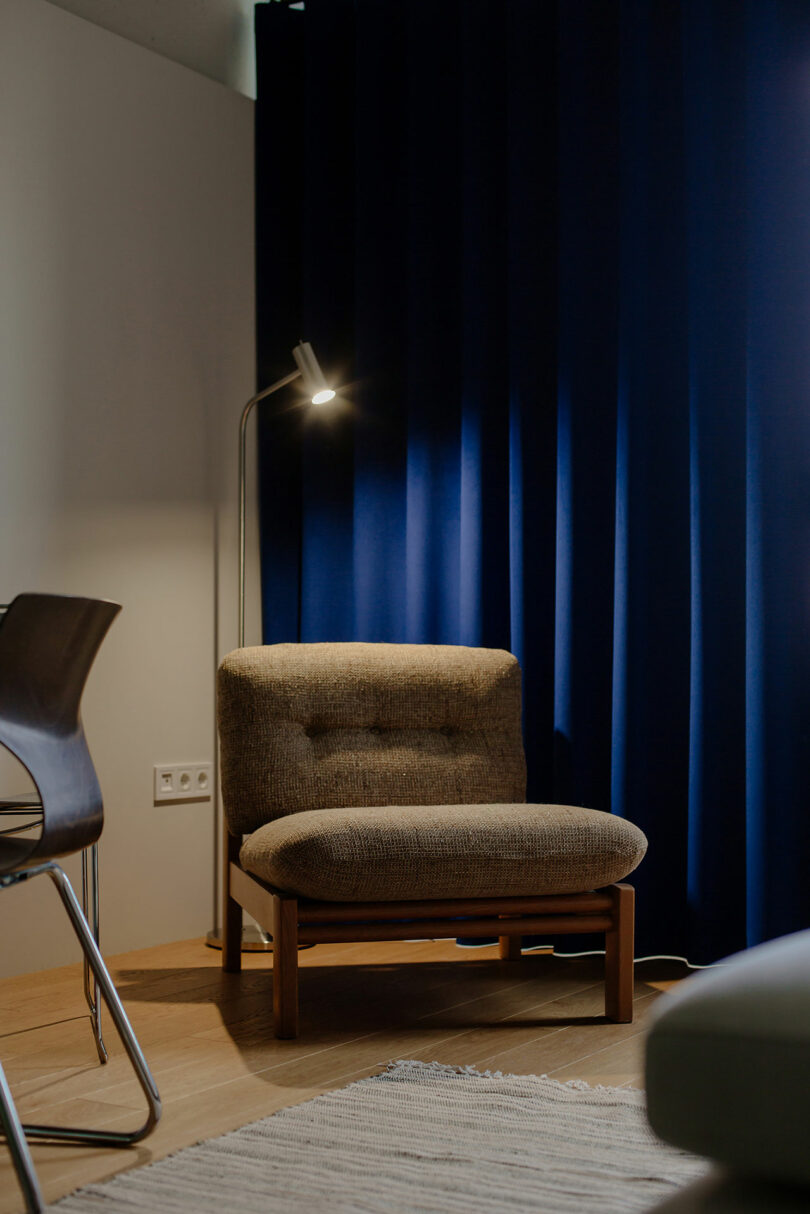 vignette of modern surviving room pinch brownish chair successful beforehand of agleam bluish curtain