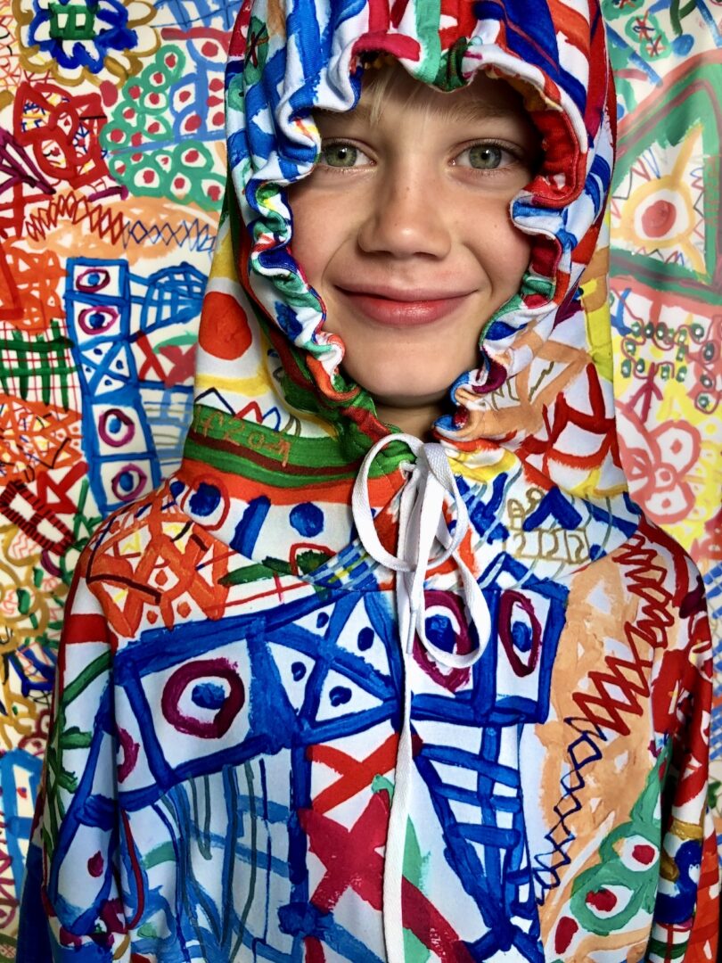 child wearing a colorful schematic hooded sweatshirt
