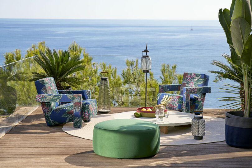 two blue floral patterned outdoor armchairs and green ottoman