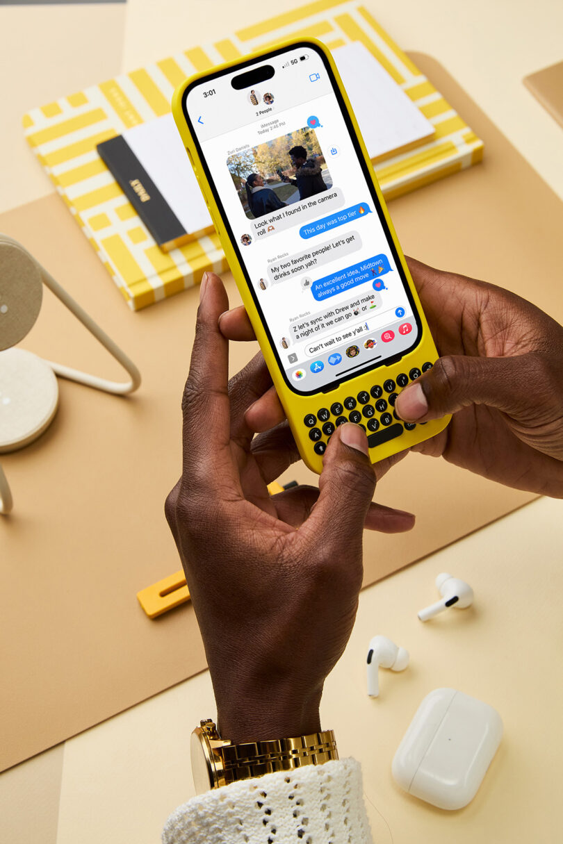 Person holding yellow Clicks iPhone case in both hands while text messaging