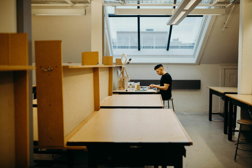 Perspective of person modeling in empty architecture studio.