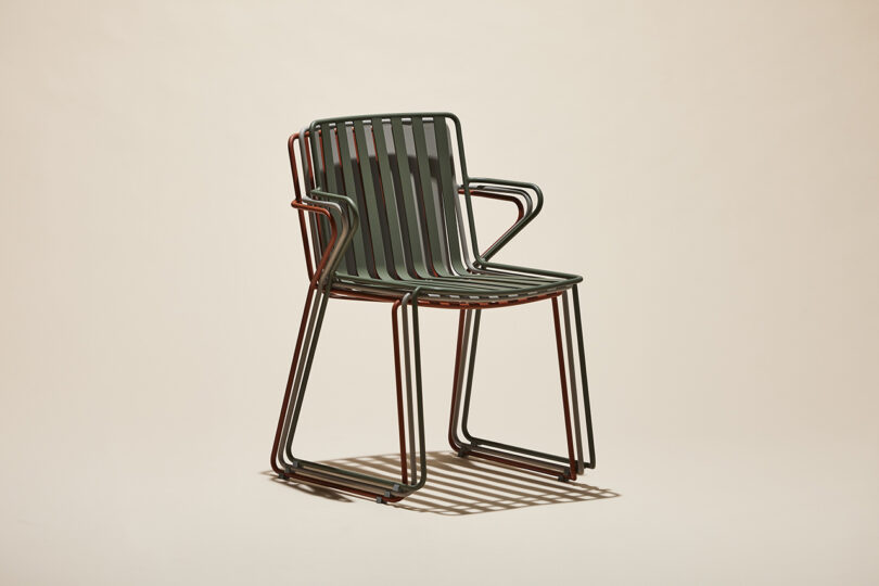 three stacked slatted metal outdoor chairs