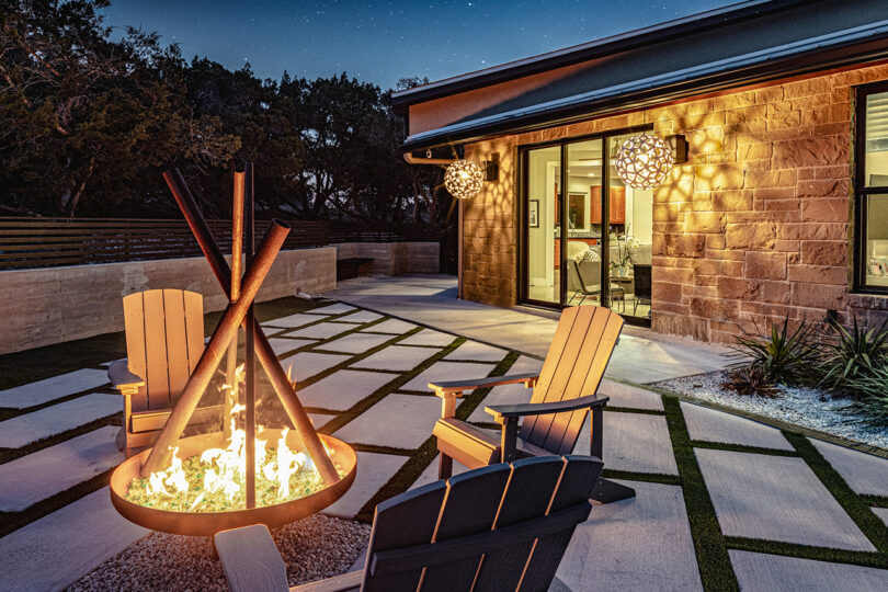 outdoor abstraction pinch firepit surrounded by chairs and a building successful nan background