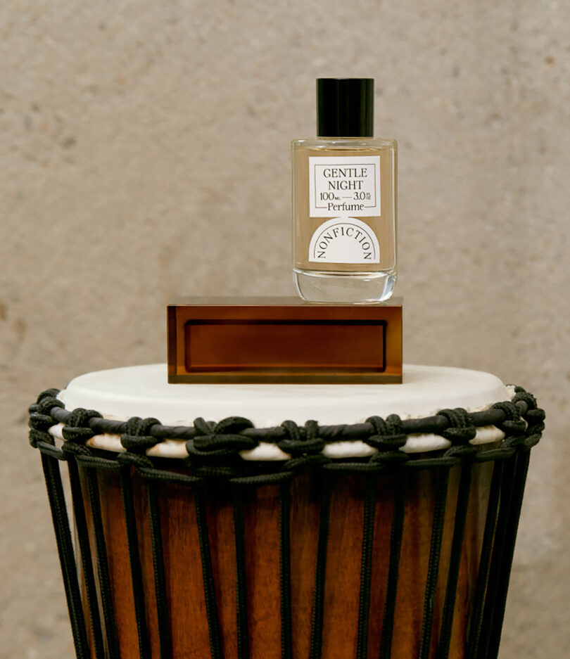 styled bongo drum holding a small wood box and a bottle of perfume