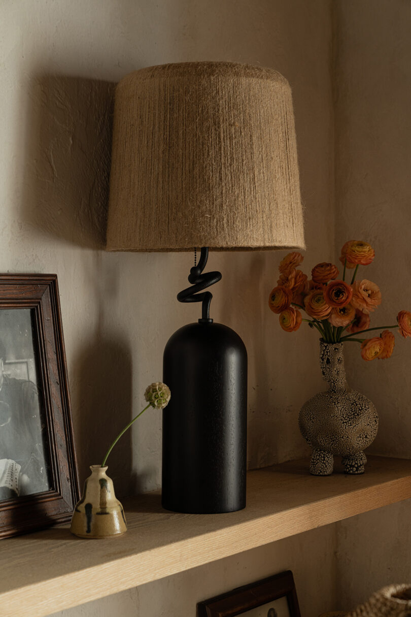 black based table lamp with woven shade on styled table