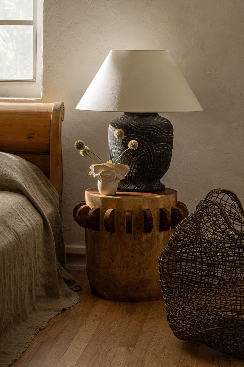 table lamp with a large black base and white shade on a bedside table