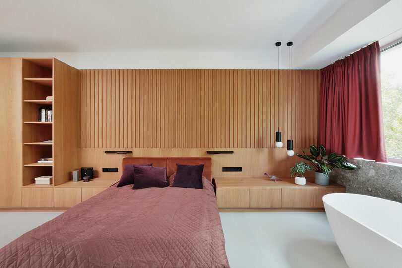 modern bedroom with built-in wood headboard wall and bed with attached tables