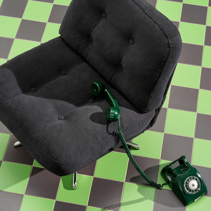down view of black upholstered tufted chair on green and black checkered tile