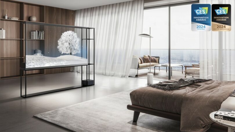 LG OLED Signature T in the middle of a large contemporary bedroom setting with wood panel walls and large ocean view windows, with a bed visible on the right.