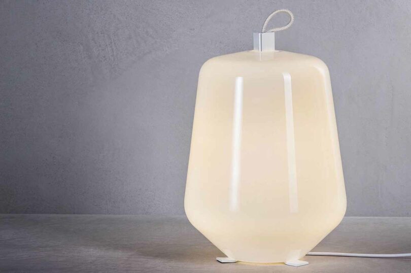 illuminated three-footed glass and metal table lamp