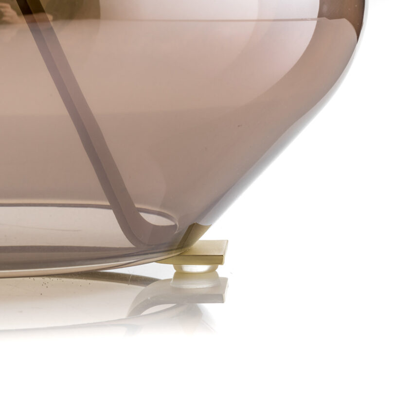 detail of three-footed glass and metal table lamp