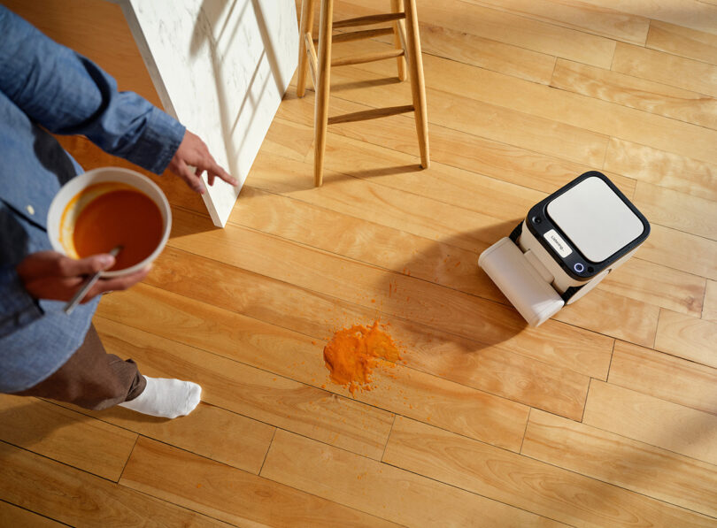Person pointing at spilled tomato soup for their robotic vacuum to mop up.