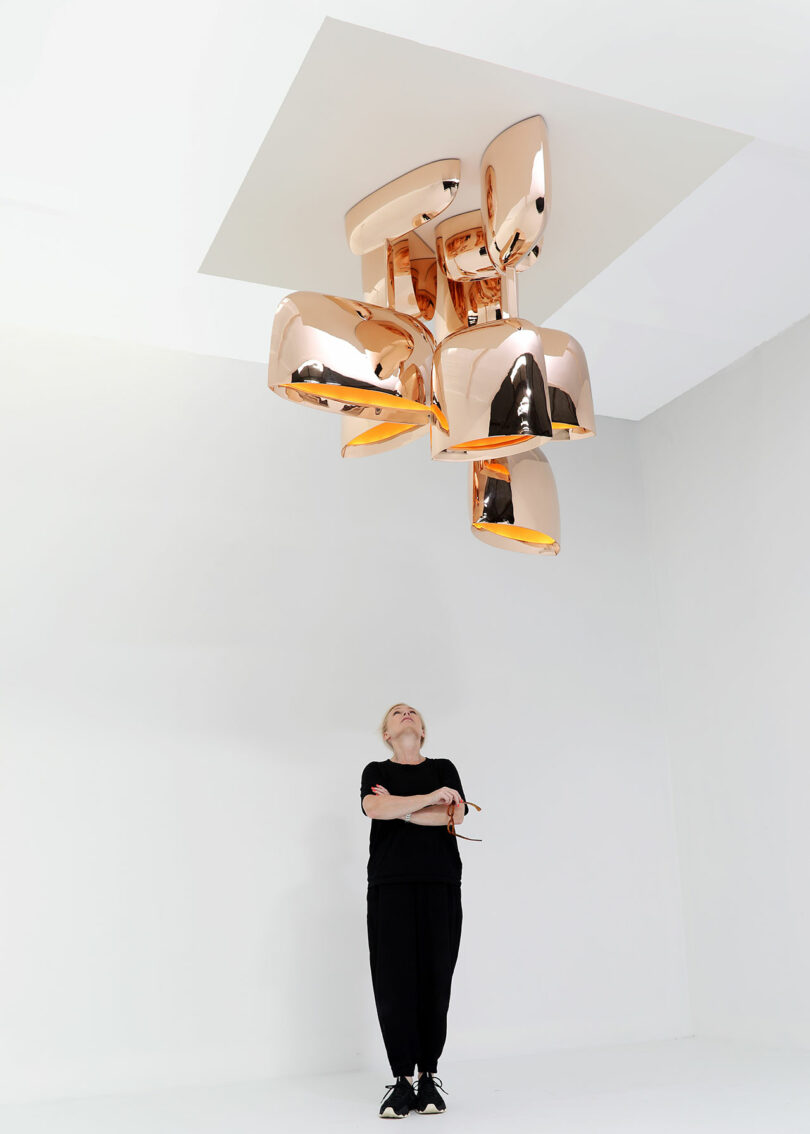 A female opinionated beneath a sculptural bronze chandelier.