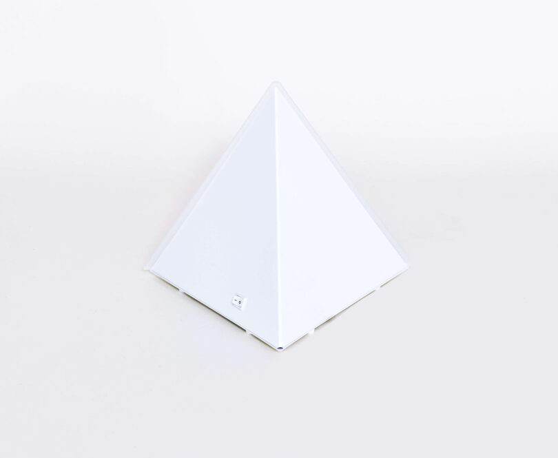 Pyramid shaped Mini LUXOR Desk Lamp, front angled view turned off, against white background.