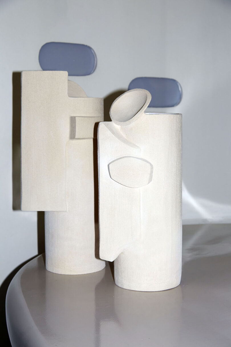 duas peças de cerâmica branca com formas geométricas adicionadas às suas superfícies