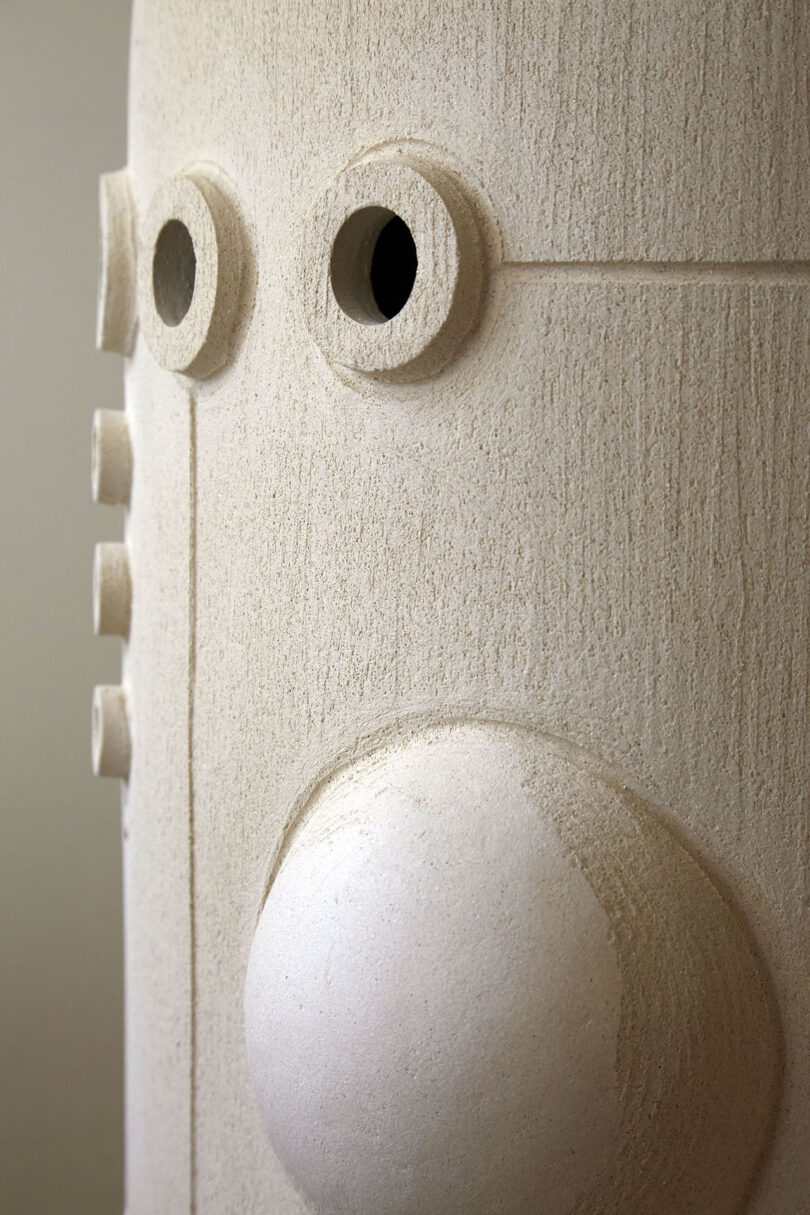white ceramic piece with geometric shapes added to its surface