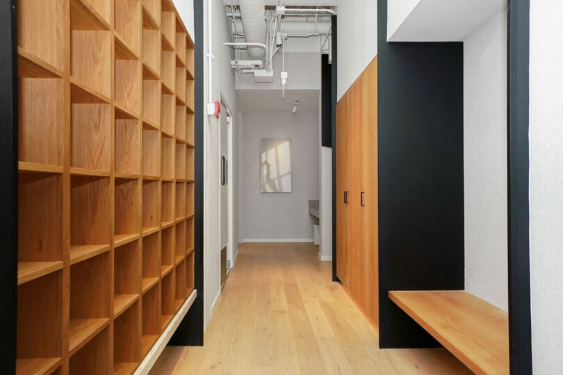 A hallway lined with custom gym cubbies, closets, and seating.