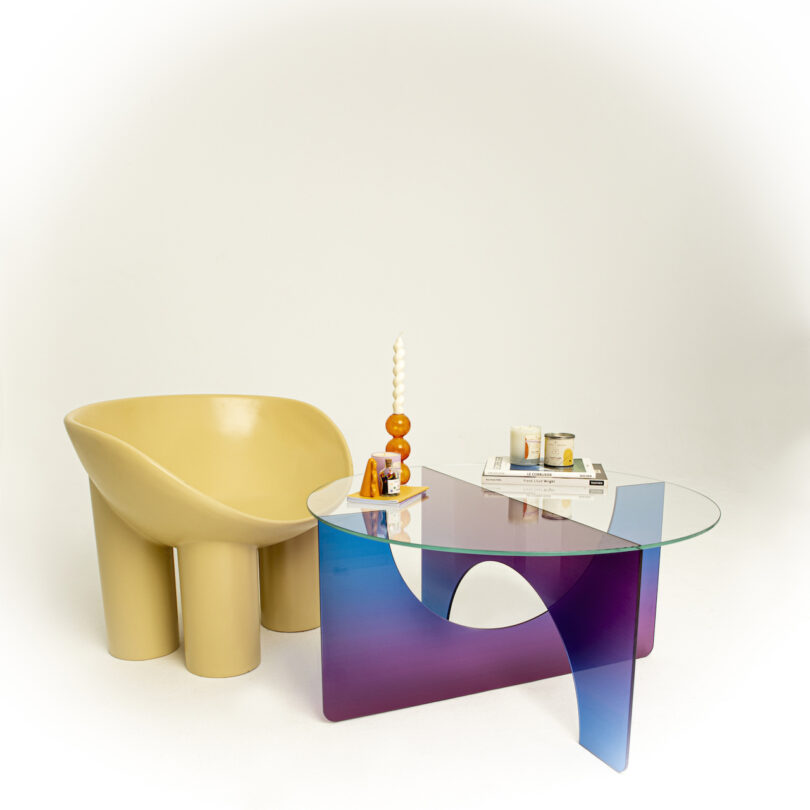 mesa de centro gradiente roxa e azul ao lado de uma cadeira amarela