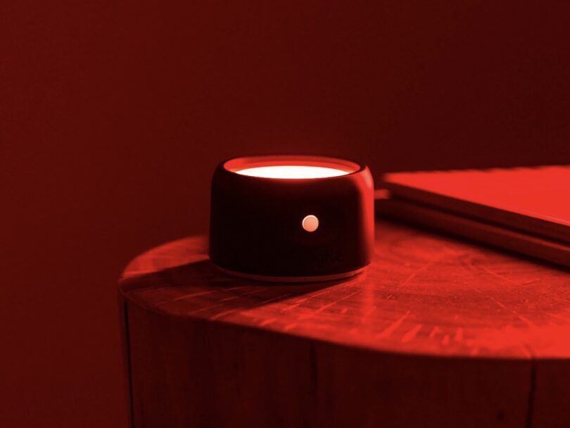 Helight Sleep red light therapy device on a side table emitting red light into a dark room
