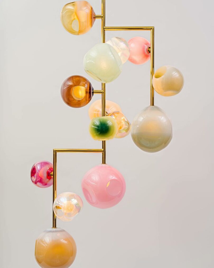 Jamie Harris Studio chandelier of hand-blown glass pieces in shades of pink, amber, and white pearl.