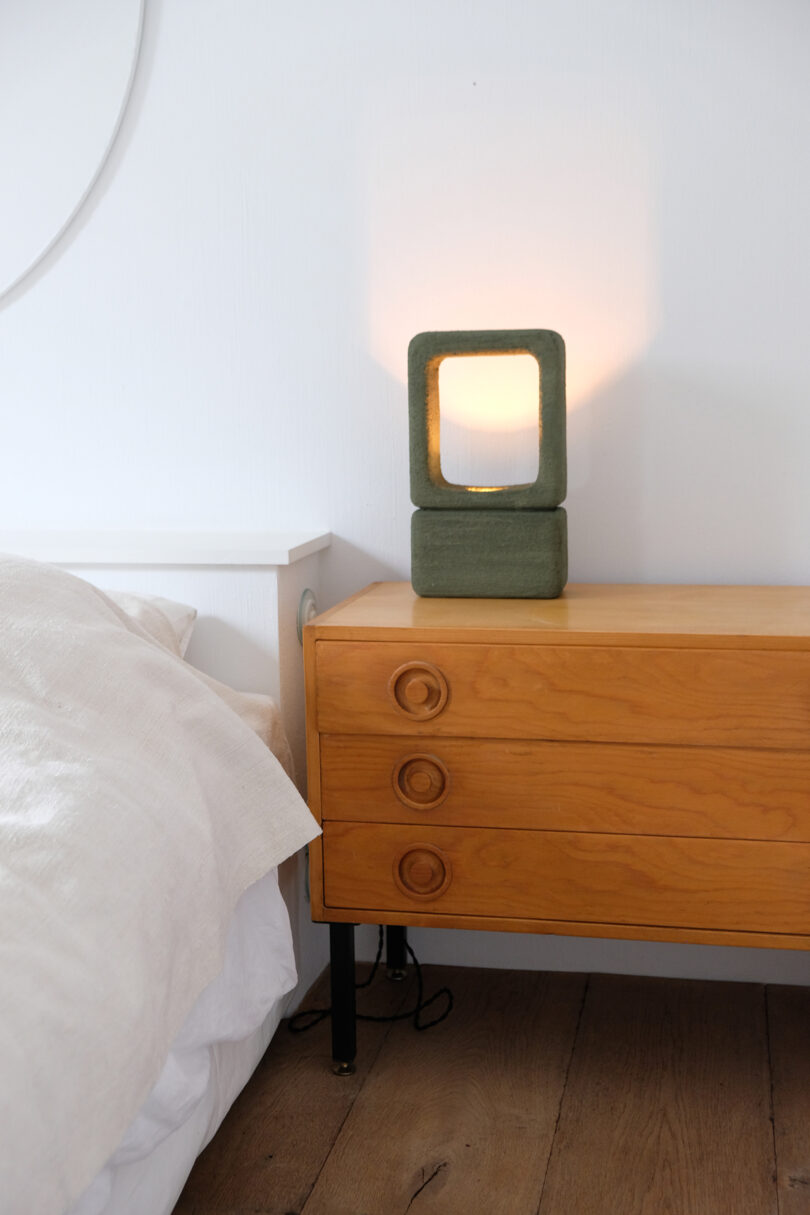 dark green handmade lighting object on a nightstand