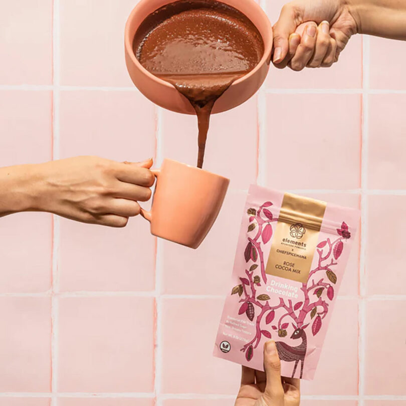 Someone pouring basking cocoa into a mug.