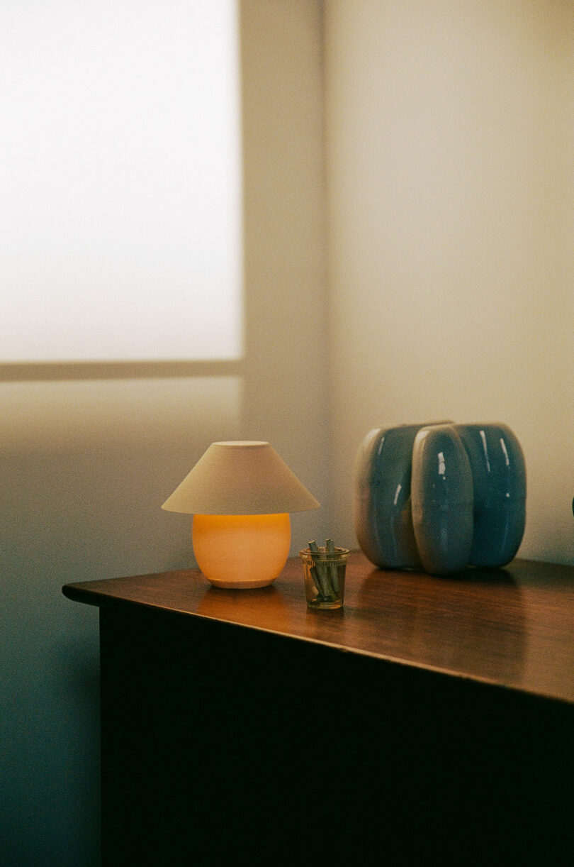 A mini orb-shaped lamp pinch accepted shadiness sitting connected a dresser.