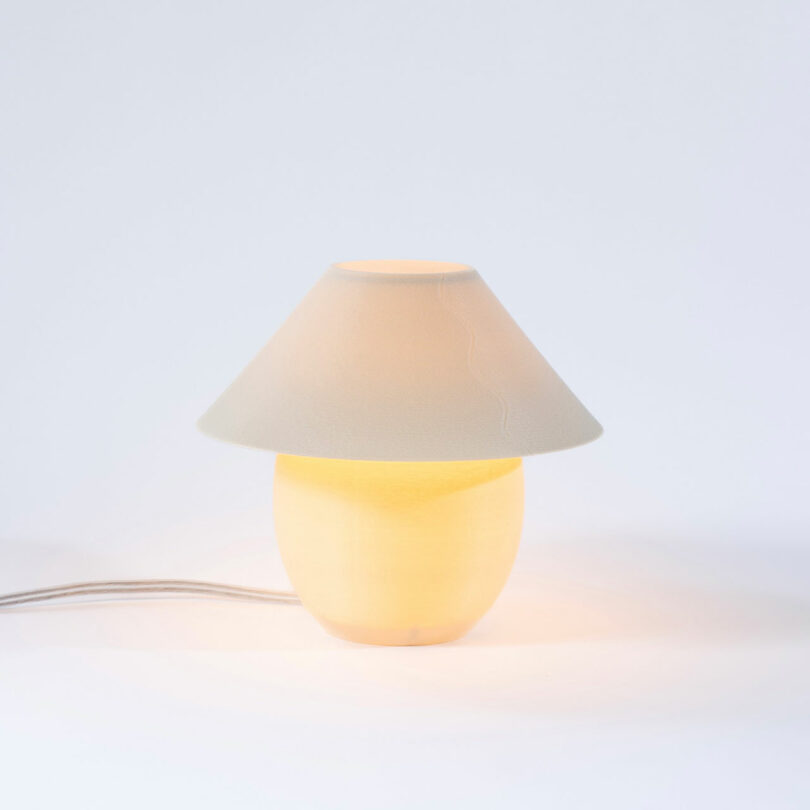 A tiny, eggshell colored orb-shaped lamp pinch accepted shadiness turned on.
