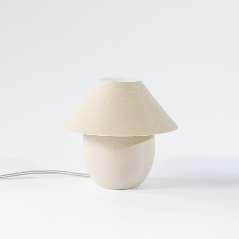 A tiny, eggshell colored orb-shaped lamp pinch accepted shadiness turned off.