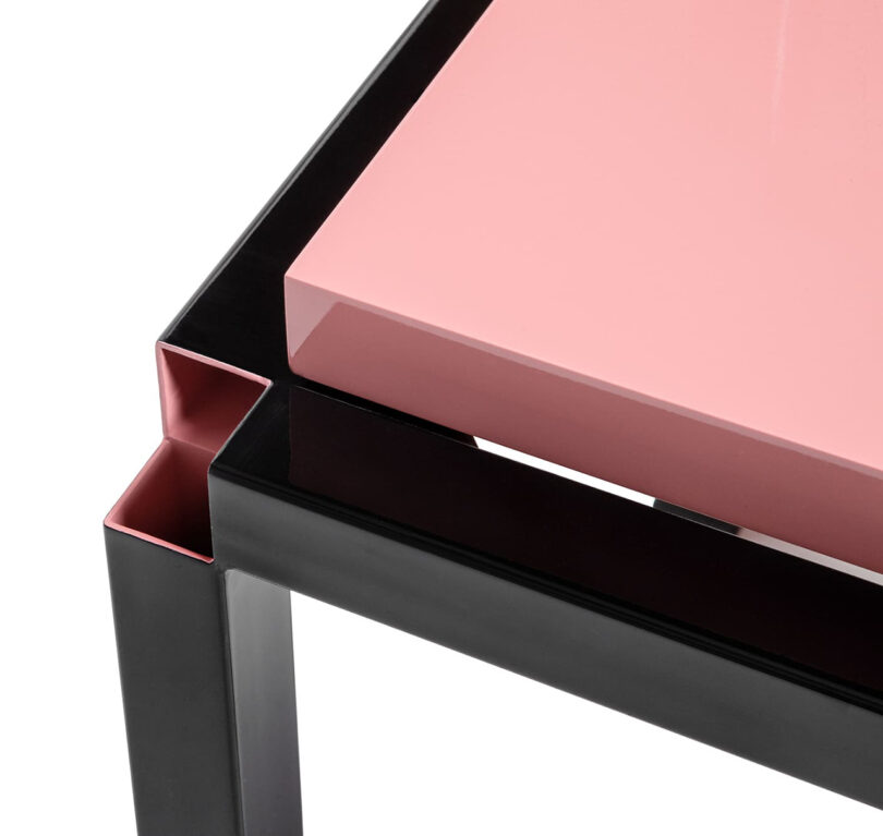 detail of zero-thickness black framed chair with pink seat