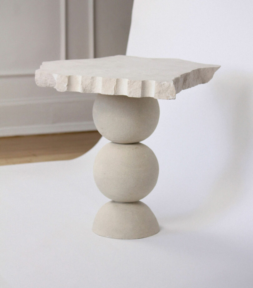 grey table with three stacked balls and jagged tabletop